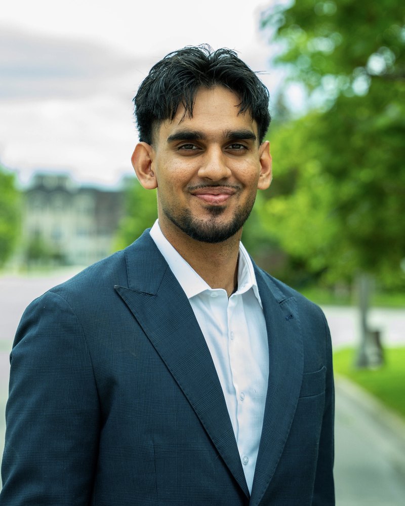 Arjun Bhardwaj in a navy blazer, smiling outdoors